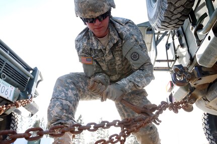 Pfc. Nicholas White, a truck driver with the 619th Transportation Company, secures a Canadian vehicle aboard a flatbed trailer at Canadian Army Base Valcartier located just outside Quebec City, Quebec on March 16 before  beginning a more than 2,500-mile journey across the country of Canada in support of Exercise Maple Caravan 15. The exercise which runs from March through June will ultimately involve more than 300 Army Reserve and National Guard Soldiers as well as numerous Canadian Army Soldiers in a joint effort to move approximately 60 loads of Canadian Army equipment from Canadian Forces Base Valcartier near Quebec to Canadian Forces Base Wainwright. Short of an actual deployment, Maple Caravan 15 provides the most realistic and dynamic transportation training experience possible. Soldiers will experience cross-border logistics, inclement weather conditions, operating on foreign roadways and interacting with the Canadian Army. This historic logistical exercise marks the first time an Army Reserve transportation unit has conducted a long haul mission across Canada. (U.S. Army Photo by 1SG Tyrone Walker, 210th MPAD)