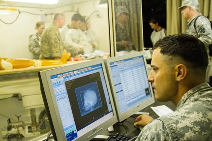 Spc. Nick Cortez, 228th Combat Support Hospital, 807th Medical Command, sits at the workstation preparing the only mobile CT scanner in the Army Reserve for use during the 2015 Global Medic Exercise at Fort McCoy, Wis., June 17, 2015.  Global Medic is a joint and combined exercise that gives Army Reserve Soldiers the opportunity to practice their medical skills in a mobile hospital environment with members of the US Navy, US Air Force and the British army reserve. (U.S. Army Photo by Sgt. 1st Class Adam Stone/Released)
