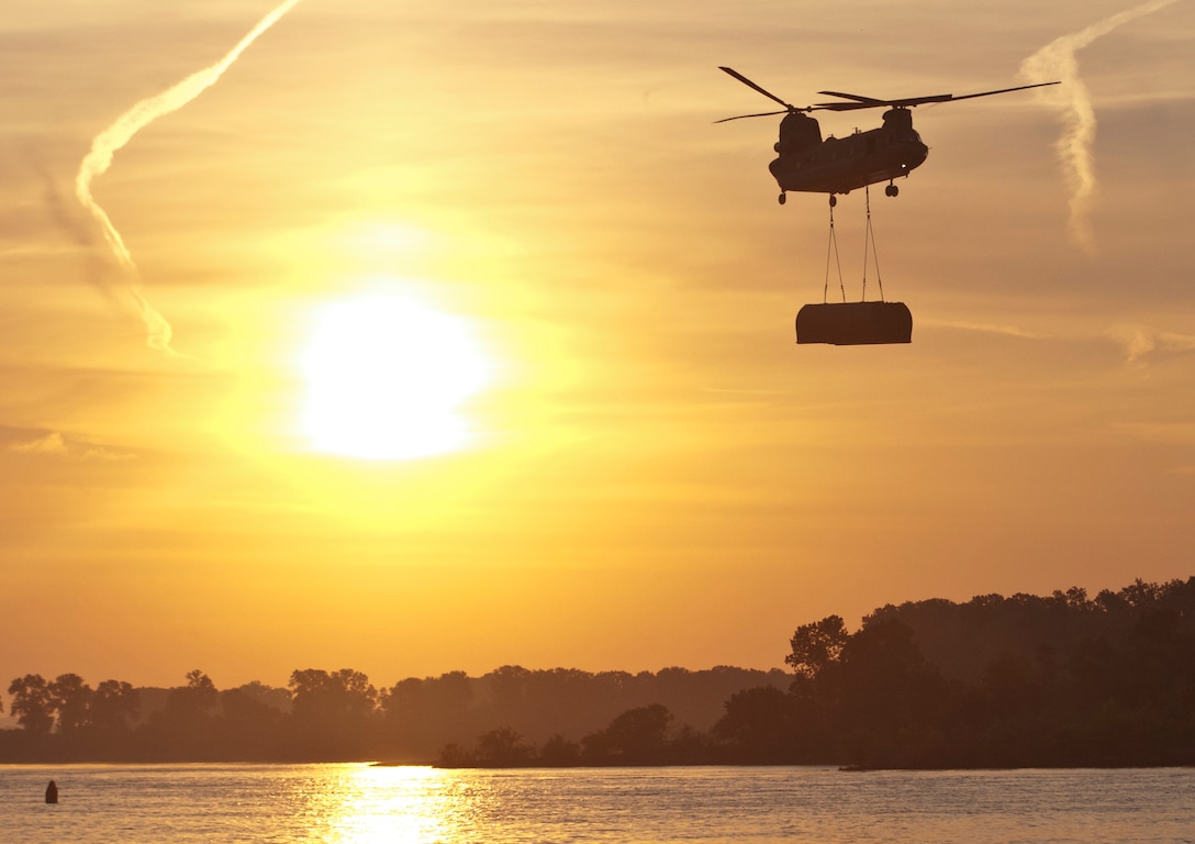 A CH-47 Chinook helicopter flown by Bravo Company, 7th Battalion, 158th Aviation Regiment, out of Fort Hood, Texas, transports a bridge bay to the Arkansas River Aug. 4 during the gap crossing, the culminating event of Operation River Assault 2015. Together, four Multi-Role Bridge Companies created an Improved Ribbon Bridge spanning 47 bays and 327 meters across the river. (U.S. Army photo by Staff Sgt. Debralee Best)