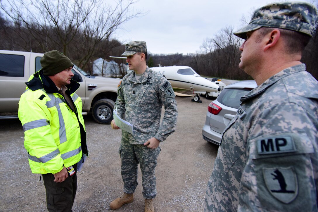Army Capt. Scott McCollum, center, talks with a member of the emergency management team before a briefing in Perryville, Mo., Jan. 1, 2016. McCollum is a military police officer assigned to the Missouri National Guard’s 1137th Military Police Company. Missouri National Guard photo