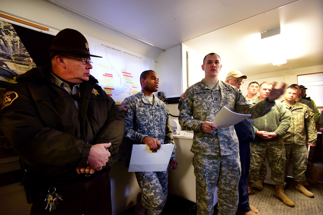 Army Capt. Scott McCollum, center, and Army 1st Lt. Markland Anderson brief members of the emergency management team and local law enforcement officers in Perryville, Mo., Jan. 1, 2016. McCollum and Anderson are military police officers assigned to the Missouri National Guard’s 1137th Military Police Company. Missouri National Guard photo