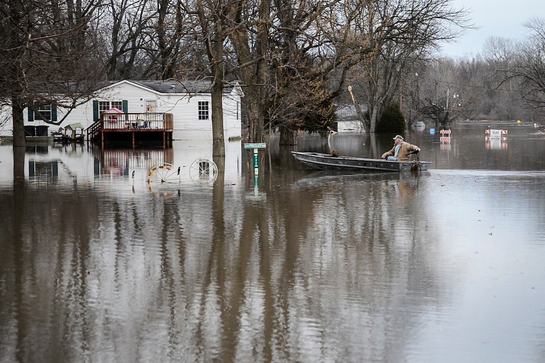 A resident rides his boat through flood waters to check on his home in Commerce, Mo., Dec. 31, 2015. Missouri National Guard photo