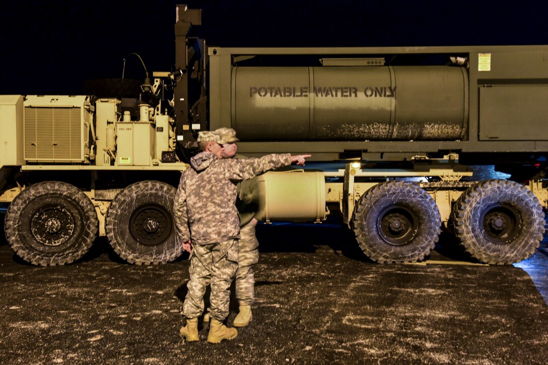 Army National Guardsmen discuss their plan to stage potable water tankers at an elementary school in High Ridge, Mo., Jan. 1, 2016. Missouri National Guard photo