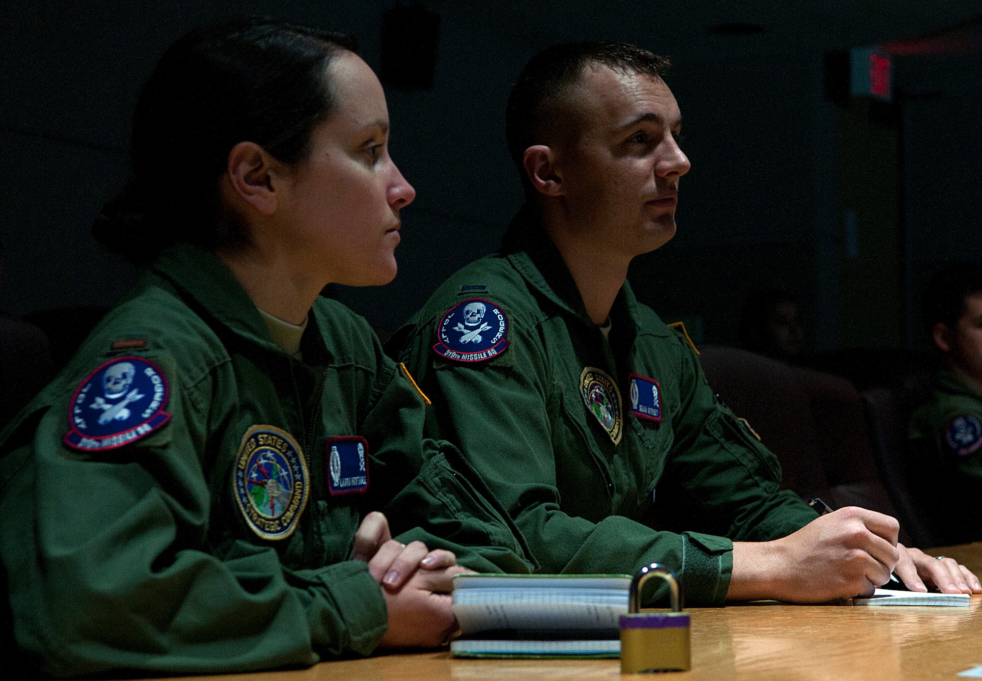 Air Force 1st Lt. Sean Street, right, and 2nd Lt. Laura Huxtable, 319th Missile Squadron, listen to a briefing inside the 90th Operations Group on F.E. Warren Air Force Base, Wyo., Dec. 31, 2015, as they prepare to depart to the missile field to stand alert into the New Year. During their alert mission the two missileers received a phone call from Gen. Paul Selva, vice chairman of the Joint Chiefs of Staff, wishing them a happy New Year. (U.S. Air Force photo by Senior Airman Brandon Valle)