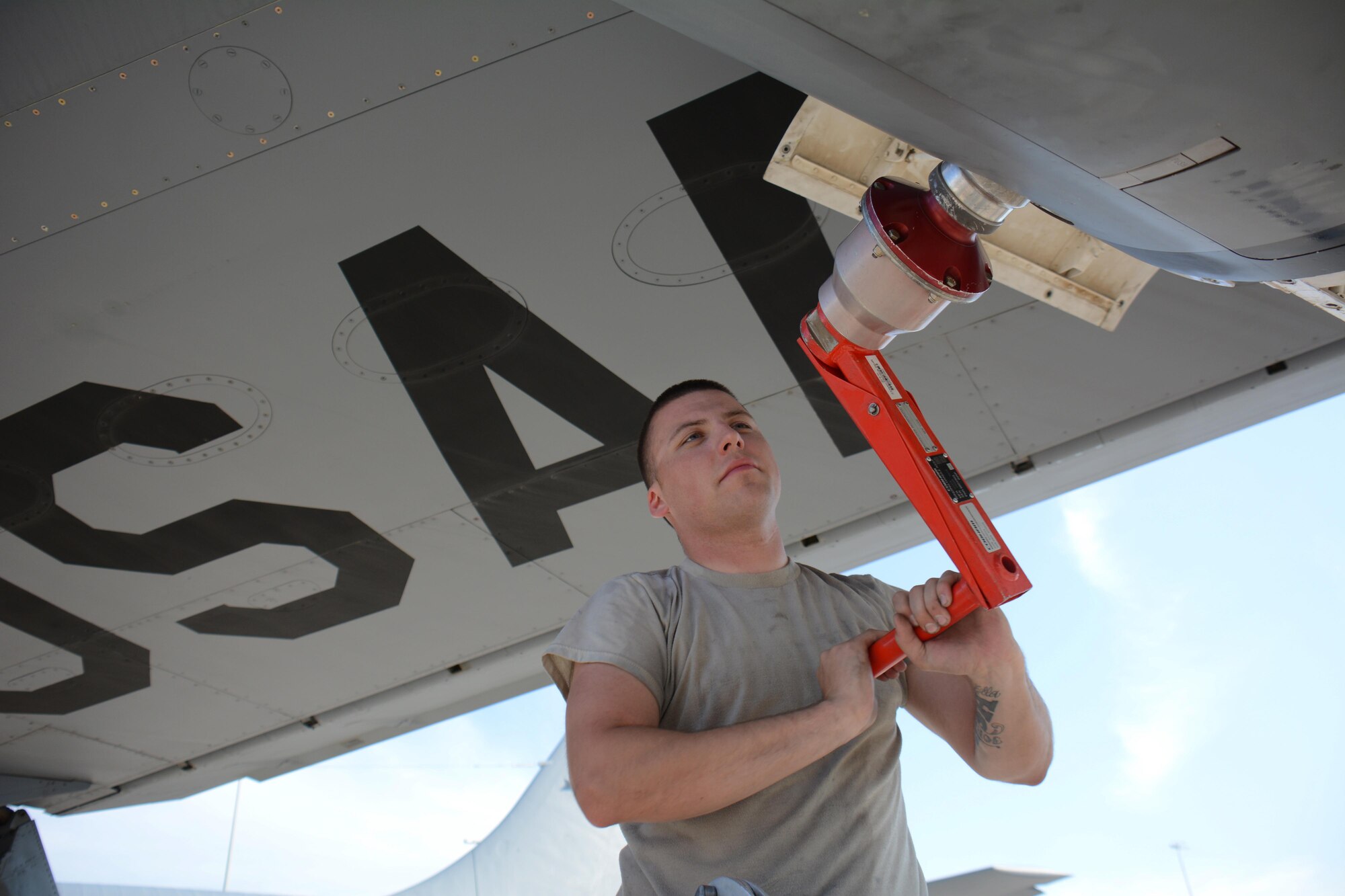 Senior Airman Reid Nixon, 340th Expeditionary Aircraft Maintenance Unit hydraulics journeyman from Odenton, Maryland, winds out a multi-purpose refueling system hose and basket with a MPRS winding handle after installing the system on a KC-135 Stratotanker at Al Udeid Air Base, Qatar, Dec. 30, 2015. The system allows the aircraft to refuel any plane supporting Operation Inherent Resolve. (U.S. Air Force photo by Tech. Sgt. James Hodgman/Released)