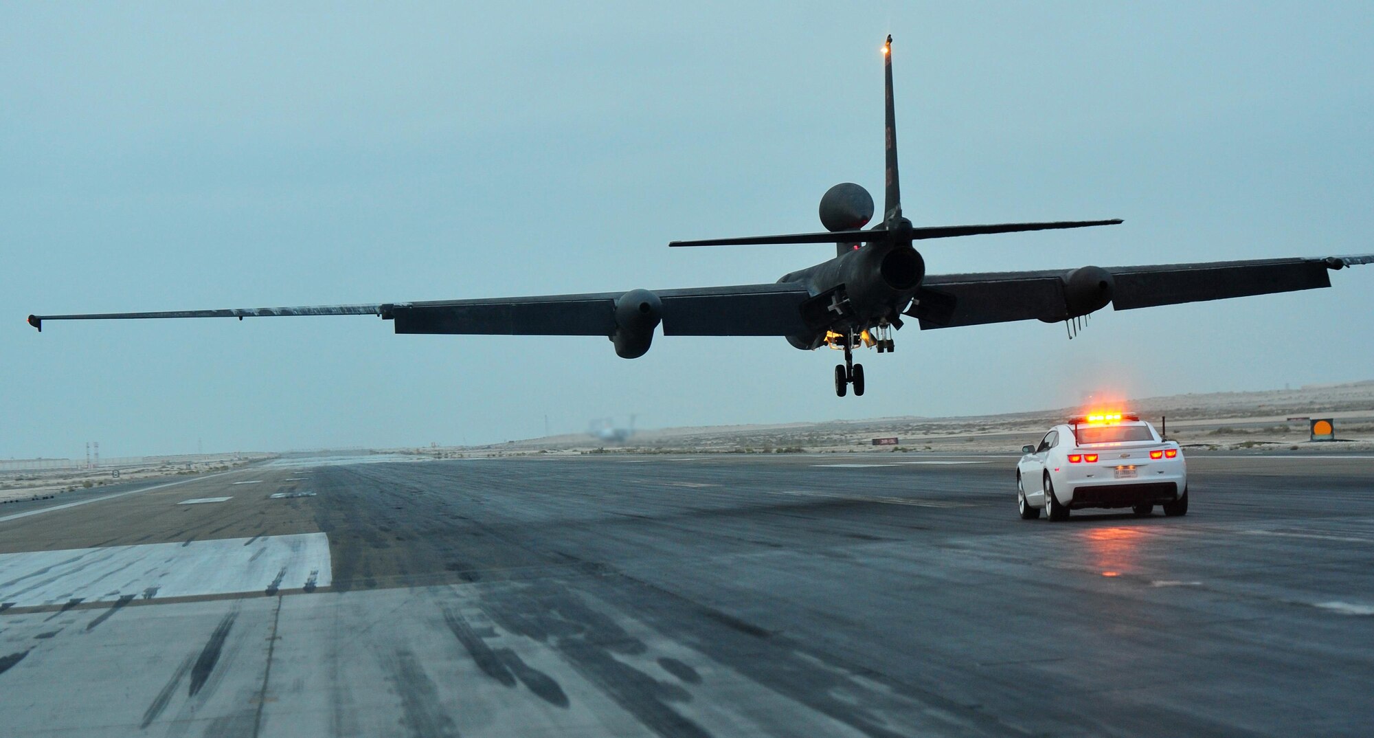 A mobile chase car driver pursues a U-2 Dragon Lady reconnaissance aircraft during its landing at an undisclosed location in Southwest Asia, Dec. 7, 2015. Mobile chase car drivers act as a second pair of eyes and ears for U-2 pilots during their launch and landings, radioing adjustments to the aircraft to make up for the pilot’s limited sight of the runway. (U.S. Air Force photo by Staff Sgt. Kentavist P. Brackin/released)