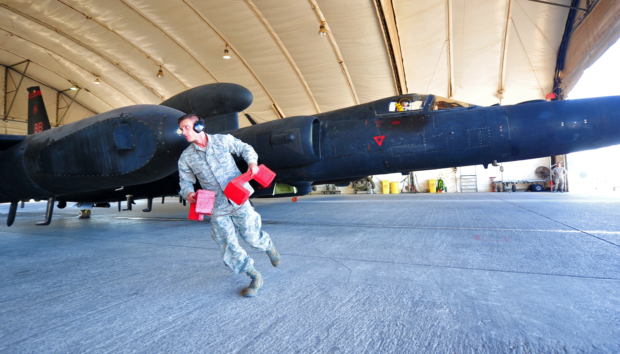 Staff Sgt. Sigfred, Dragon Aircraft Unit maintainer for the U-2 Dragon Lady reconnaissance aircraft, removes aircraft blocks prior to the departure of a U-2 at an undisclosed location in Southwest Asia, Dec. 10, 2015. Despite the variety of manned and unmanned aircraft that have been proposed to take over the U-2’s ISR role in the 60 years since its activation, it still remains a primary reconnaissance aircraft for the Air Force. (U.S. Air Force photo by Staff Sgt. Kentavist P. Brackin/released)