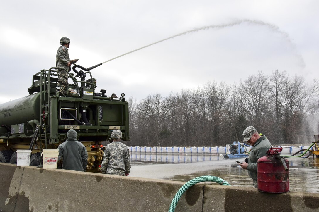 Army combat engineers help Missouri's Transportation Department workers with flood relief efforts in Arnold, Mo., Dec. 31, 2015. The engineers are assigned to the Missouri National Guard's 220th Engineer Company. Missouri National Guard photo