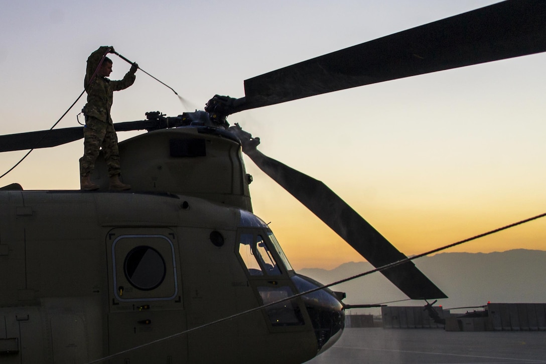 A U.S. soldier washes a CH-47 Chinook helicopter on Bagram Airfield, Afghanistan, Dec. 29, 2015. The soldier is assigned to the Michigan National Guard's Company B, Headquarters Company, 3rd Battalion, 238th Aviation Regiment, General Support Aviation Brigade. U.S. Army photo by Sgt. 1st Class Nathan Hutchison