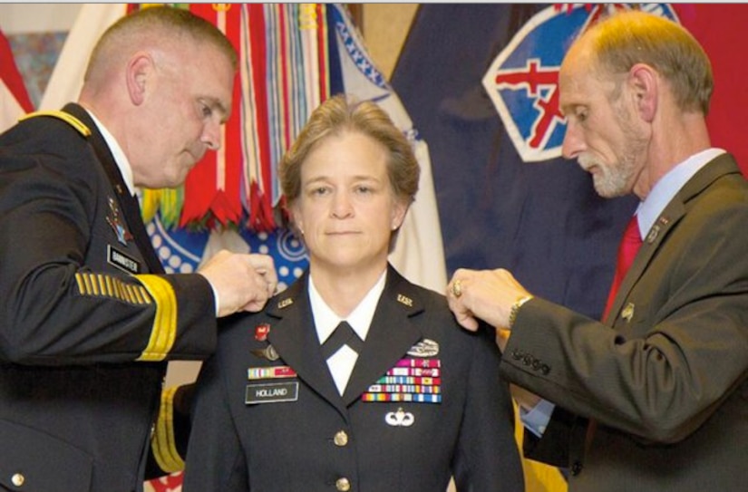 Brig. Gen. Diana Holland becomes the first woman to hold the title of deputy commanding general for support in a light infantry division during her promotion ceremony to brigadier general on Fort Drum, N.Y., July 29, 2015. Her husband, James Holland Jr., right, and Army Maj. Gen. Jeffrey L. Bannister, 10th Mountain Division and Fort Drum commander, pin on her stars.