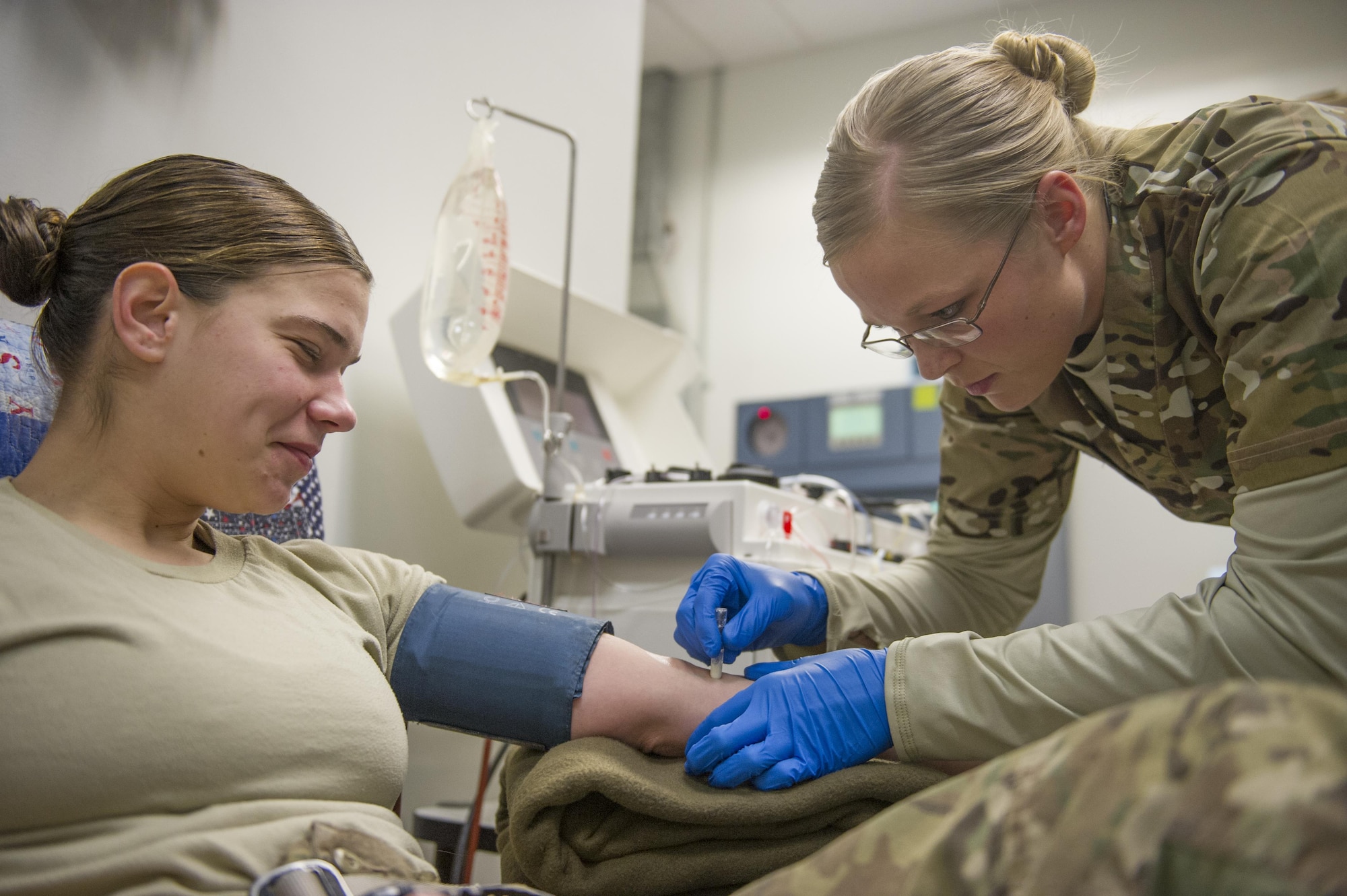 Spc. Lauren O'Neal, 153rd Blood Support Detachment medical laboratory technician, prepares Spc. Samantha Criscio, Guard Force, to give platelets at Craig Joint Theater Hospital on Bagram Airfield, Afghanistan, Dec. 31, 2015. In order to extract platelets, a critical life-saving blood component, apherisis machines are used to draw blood and return the unused portions to the donor. (U.S. Air Force photo/Tech. Sgt. Robert Cloys)