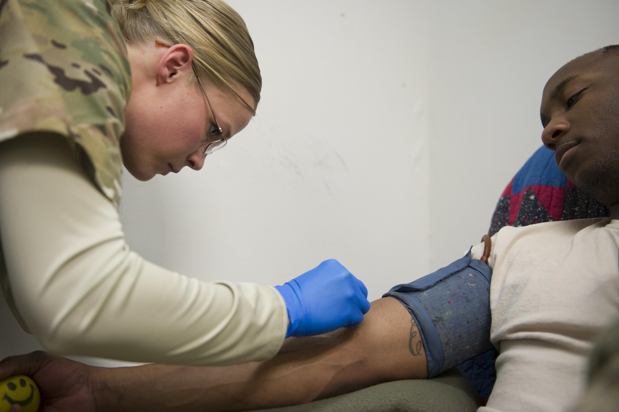 Spc. Lauren O'Neal, 153rd Blood Support Detachment medical laboratory technician, prepares Pfc. Zeon Battise, Guard Force, to donate platelets at Craig Joint Theater Hospital on Bagram Airfield, Afghanistan, Dec. 31, 2015. In order to extract platelets, a critical life saving blood component, apherisis machines are used to draw blood and return the unused portions to the donor. (U.S. Air Force photo/Tech. Sgt. Robert Cloys) 