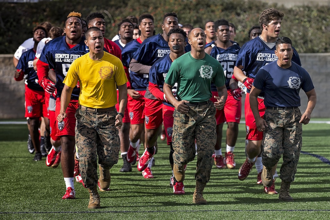 Marine Corps drill instructors take high school football players on a motivational cadence run at Orange Coast College in Costa Mesa, Calif., Jan. 2, 2016. Students chosen to play in the Semper Fidelis All-American Bowl have athletic ability, academic achievements and character. The drill instructors are from Marine Corps Recruit Depot San Diego. U.S. Marine Corps photo by Sgt. Rebecca Eller