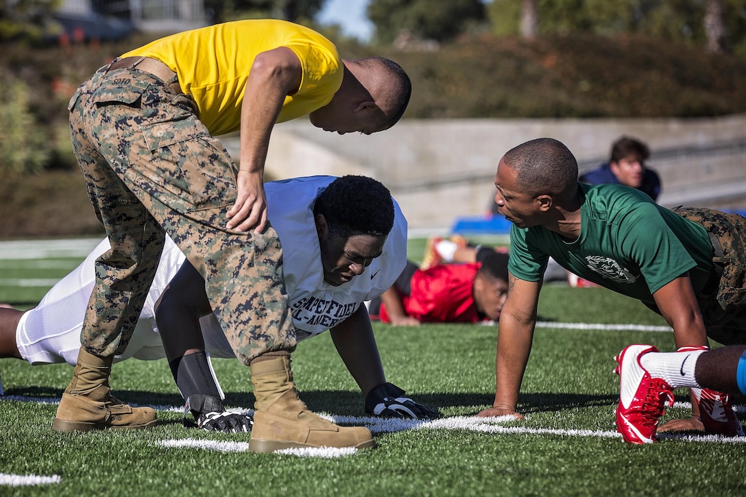 Marine Corps drill instructors motivate Denzel Okafor, offensive guard from Lewisville High School in Lewisville, Texas, during practice at Orange Coast College in Costa Mesa, Calif., Jan. 1, 2016. Okafor was one of the high school students chosen to play in the Semper Fidelis All-American Bowl. The students are selected for their athletic ability,  academic achievements and character. U.S. Marine Corps photo by Sgt. Rebecca Eller