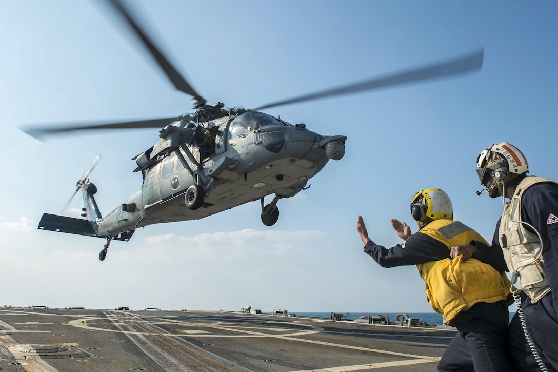 U.S. Navy Petty Officer 3rd Class K. Bailey signals an MH-60S Seahawk helicopter during takeoff from the flight deck of the guided-missile destroyer USS Bulkeley in the Arabian Gulf, Dec. 28, 2015. The destroyer is supporting maritime security operations and theater security cooperation efforts in the U.S. 5th Fleet area of responsibility. Bailey is a boatswain's mate and the helicopter is assigned to Helicopter Sea Combat Squadron 5. U.S. Navy photo by Petty Officer 2nd Class M. J. Lieberknecht