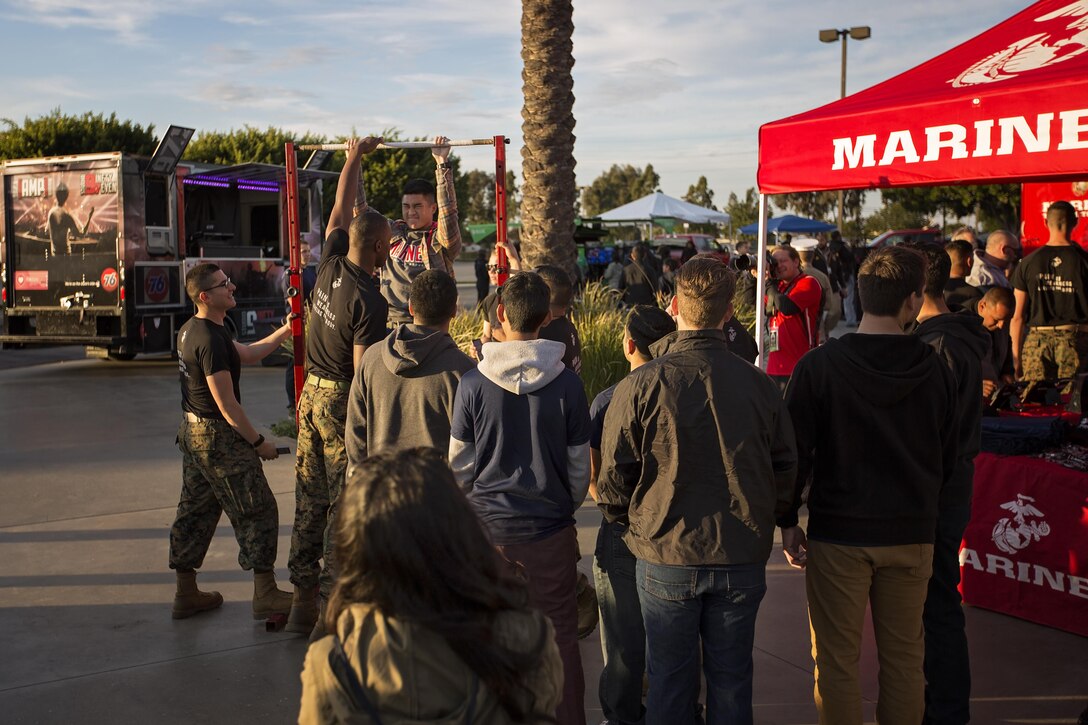 A Semper Fidelis All-American Bowl game attendee attempts pull-ups during Fan Fest at the Stubhub Center, Carson, Calif., Jan. 3, 2016. High School athletes chosen to play in the Semper Fidelis All-American Bowl are well-rounded individuals on and off the field who not only are distinguished athletes, but also have academic achievements and display exemplary moral character. (U.S. Marine Corps photo by Sgt. Rebecca Eller)