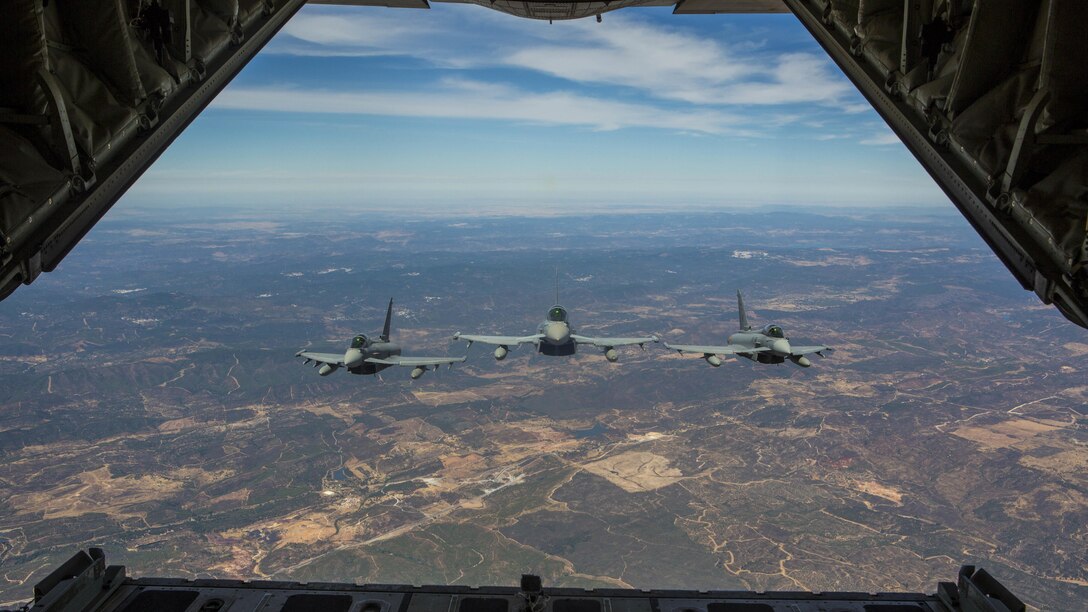 Three Eurofighter Typhoons with the Spanish Air Force escort a U.S. Marine Corps KC-130J Hercules during an aerial refueling mission, Aug. 13, in Spain. Bilateral exercises such as this one are how Spain and the U.S. foster one of the closest defense partnerships around the world.