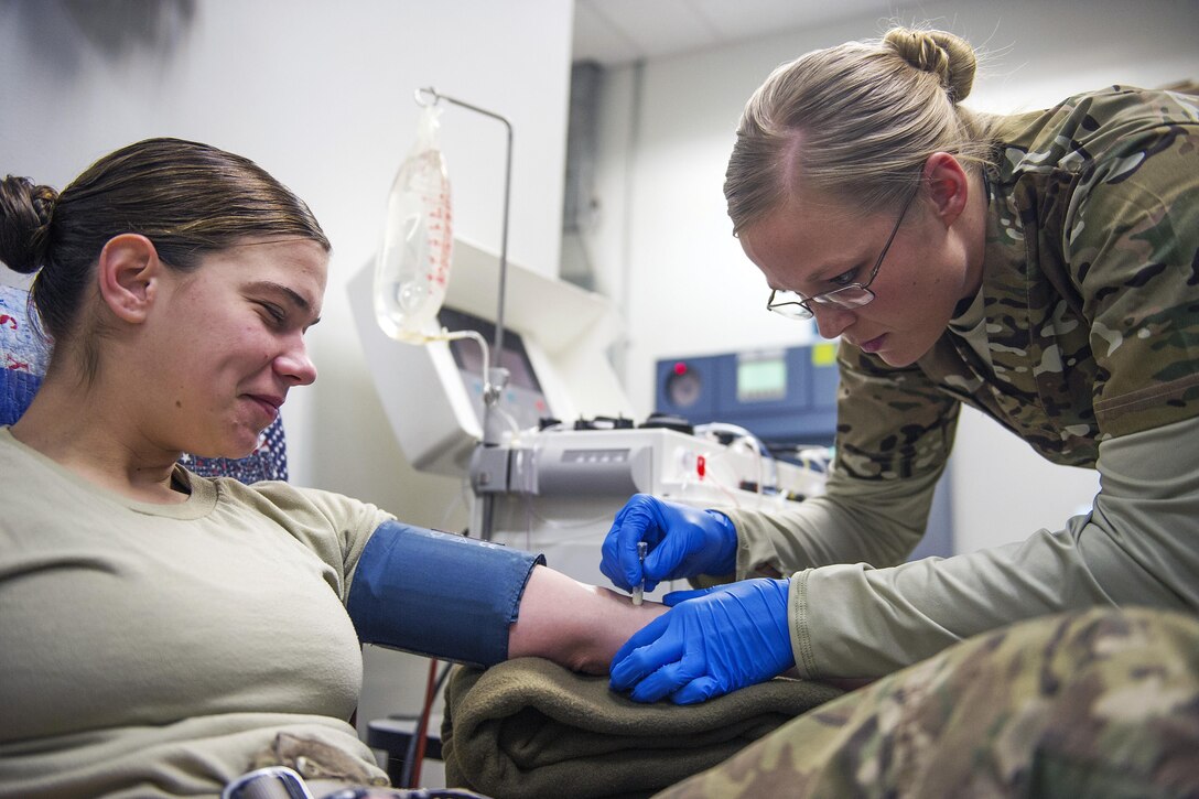 U.S. Army Spc. Lauren O'Neal prepares to receive platelets from Army Spc. Samantha Criscio at Craig Joint Theater Hospital on Bagram Airfield, Afghanistan, Dec. 31, 2015. In order to extract platelets, a critical life-saving blood component, apheresis machines are used to draw blood and return the unused portions to the donor. O'Neal is a medical laboratory technician assigned to the 153rd Blood Support Detachment.  Air Force photo by Tech. Sgt. Robert Cloys 