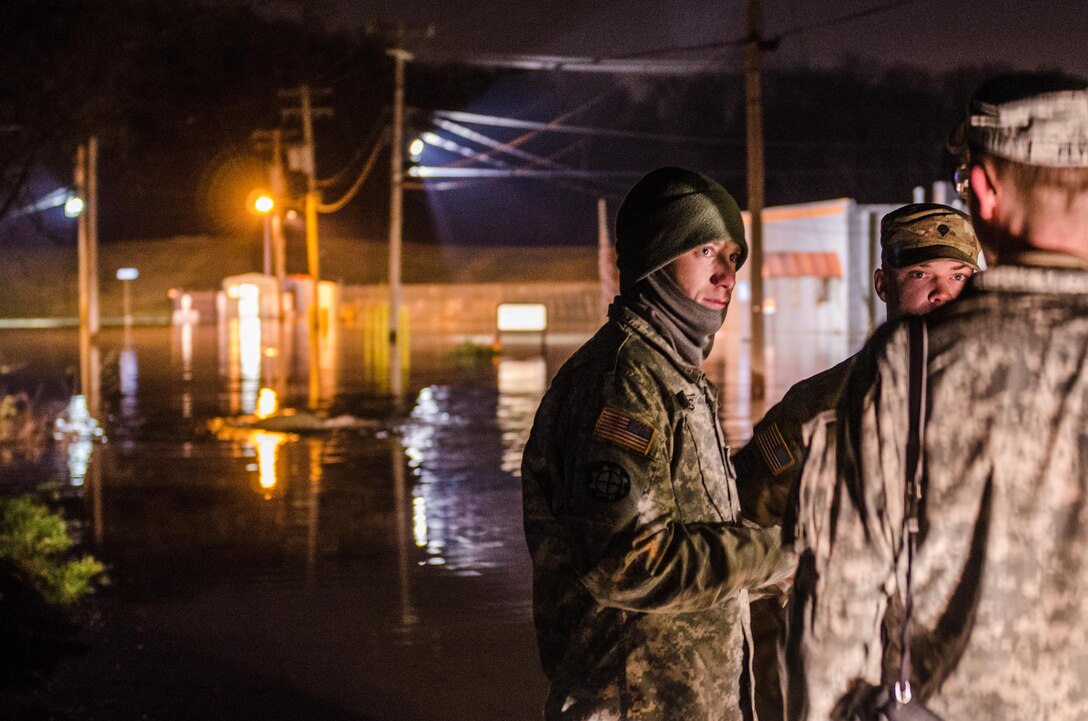 Soldiers prepare to operate a water distributor to pump water out of flooded areas back over the Valley Park levee on the Meramec River in Missouri, Dec. 31, 2015. The soldiers are assigned to the Missouri National Guard’s 220th Engineer Company. Missouri National Guard photo by Air Force Senior Airman Patrick P. Evenson