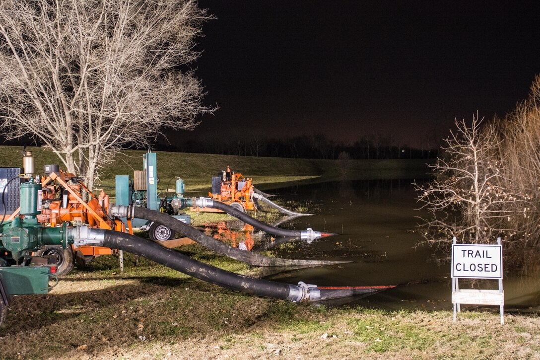 Water is pumped out of the affected areas back over the Valley Park levee on the Meramec River in Missouri, Dec. 31, 2015. Soldiers and airmen assigned to the Missouri National Guard volunteered to supported the Missouri Department of Transportation in flood relief efforts in south-central Missouri. The focus of the aid is to ensure traffic control, water purification and levee reinforcement in affected areas. Missouri Air National Guard photo by Senior Airman Patrick P. Evenson