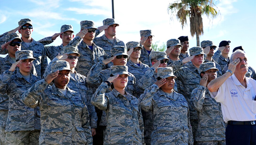 Luke Air Force Base Airmen salute as Taps plays during the POW/MIA Recognition Day Retreat ceremony Sept. 18, 2015 near the wing headquarters building at Luke AFB, Ariz.  (U.S. Air Force photo by Senior Airman Grace Lee) (Released)