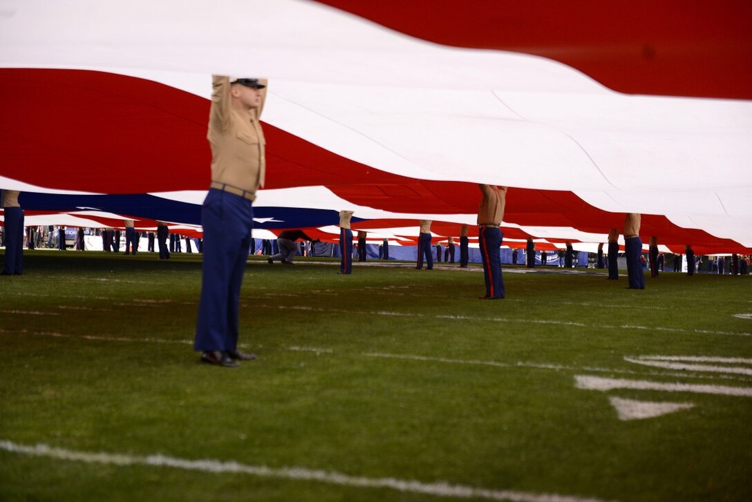 Marines support the unfurled American flag over the field of Qualcomm Stadium at San Diego, Calif., during the pre-game show at the 38th annual Holiday Bowl, Dec. 30, 2015. The flag requires a minimum of 250 people to support it while fully unfurled and covers the entire field. The Marines are with I Marine Expeditionary Force at Marine Corps Base Camp Pendleton and Marine Corps Air Station Miramar. The University of Wisconsin Badgers emerged victorious over the University of Southern California Trojans with a final score of 23-21. (U.S. Marine Corps photo by Lance Cpl. Timothy Valero)