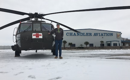 Pfc. David Mathews, a Soldier with Headquarters and Headquarters Company, 717th Brigade Support Battalion, poses next to a UH-60 Black Hawk helicopter used by the air medical evacuation (MEDEVAC) crews of Company C, 1st Battalion, 171st Aviation Regiment. The MEDEVAC was staged at the airport in Carlsbad in order to provide timely response in case of an emergency warranting their launch. Mathews, an employee of Chandler Aviation, supported the Soldiers from his civilian capacity.