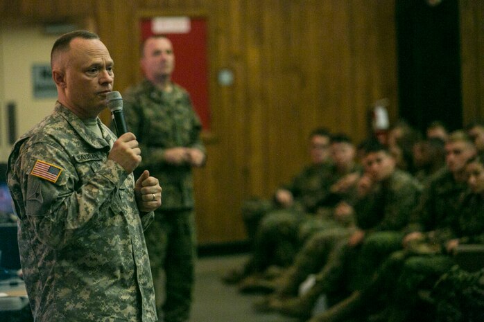 U.S. Army Chief Warrant Officer 4 Clifford W. Bauman speaks to Marines and sailors with the 2nd Marine Logistics Group during a presentation on suicide prevention at the base theater at Camp Lejeune, N.C., Dec. 15, 2015. The 2nd MLG conducted the presentation in order to create a command climate of prevention of suicides, suicide attempts and ideations through education and guided discussion. With an estimated national average of 22 veteran suicides a day, these briefs are designed to create a military culture of awareness and prevention. (U.S. Marine Corps photo by Lance Cpl. Damarko Bones/released)