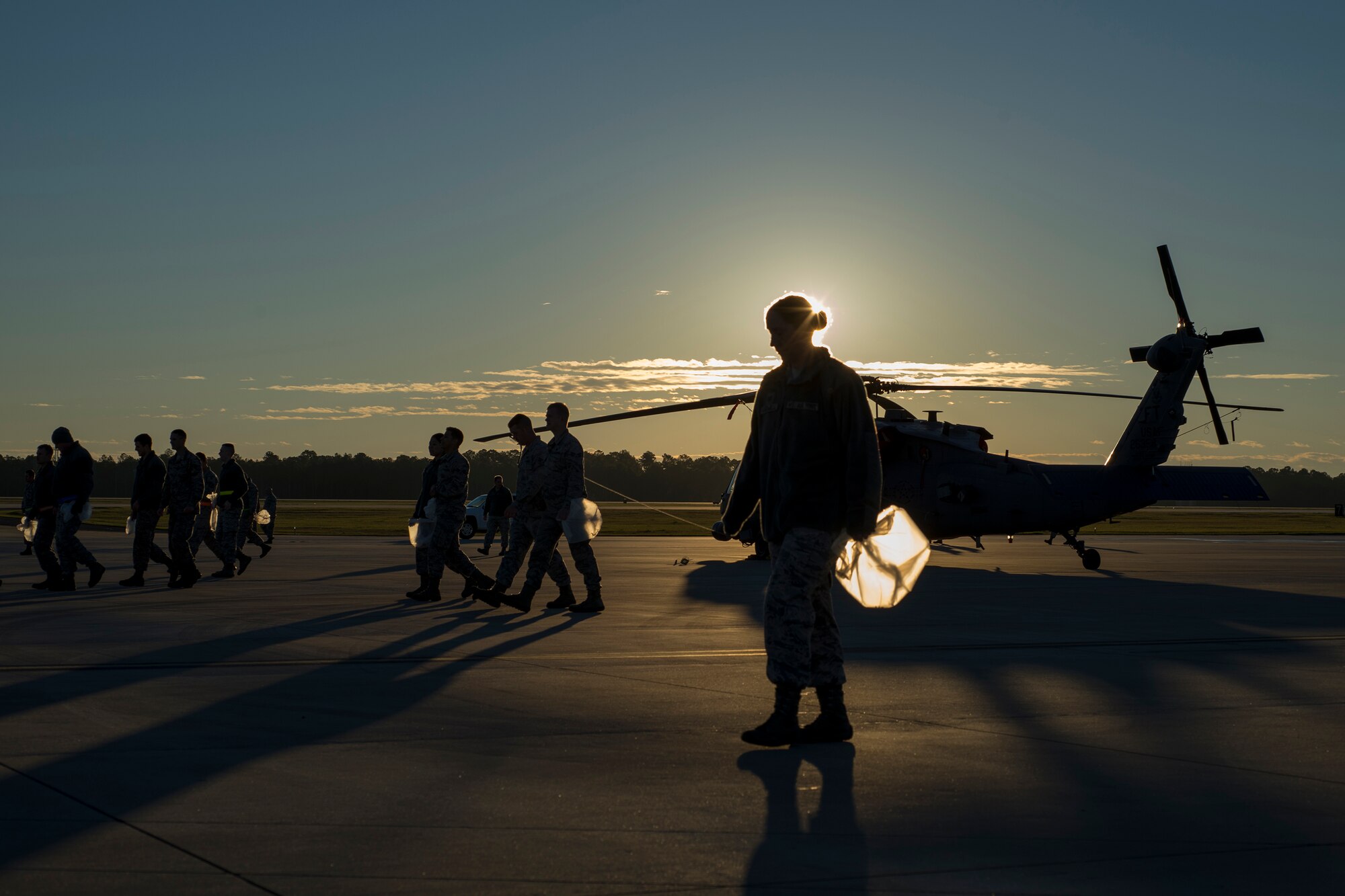 Airmen clear the area surrounding a HH-60G Pave Hawk of any foreign object debris, Jan. 4, 2016, at Moody Air Force Base, Ga. Airmen help protect Moody’s aircraft from damage by picking up FOD to ensure mission readiness. (U.S. Air Force photo by Airman Daniel Snider/Released)