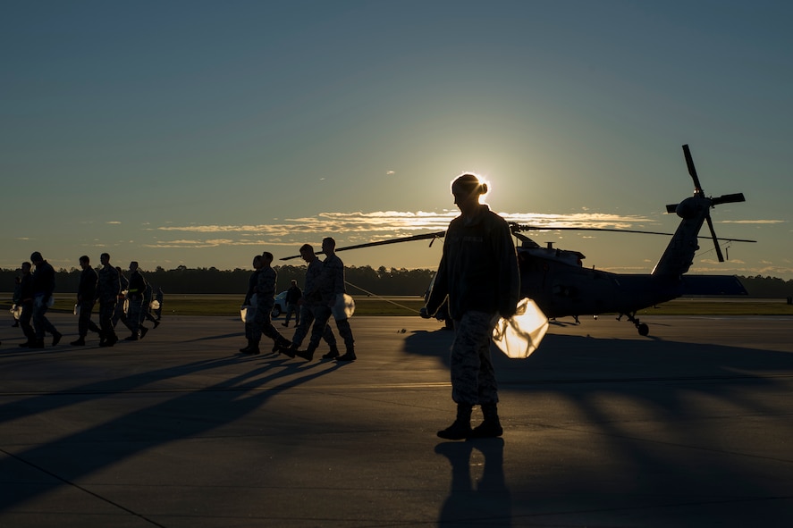 Airmen clear the area surrounding a HH-60G Pave Hawk of any foreign object debris, Jan. 4, 2016, at Moody Air Force Base, Ga. Airmen help protect Moody’s aircraft from damage by picking up FOD to ensure mission readiness. (U.S. Air Force photo by Airman Daniel Snider/Released)