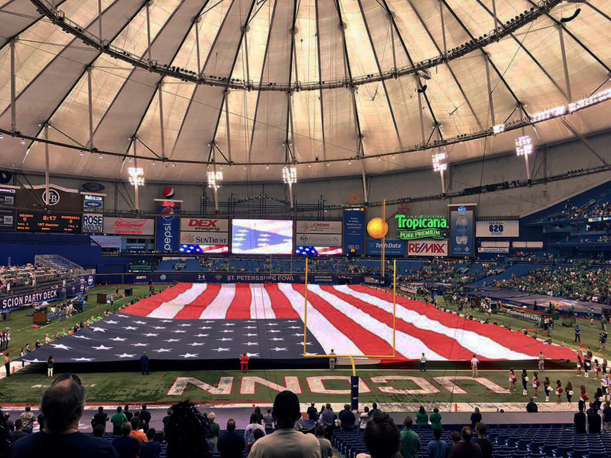 More than 100 members of the 927th Air Refueling Wing and other military affiliated organizations open the American Flag during the singing of the National Anthem at the 2015 St. Petersburg Bowl on December 26, 2015. 