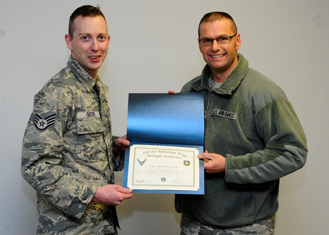 Staff Sgt. Charles Geiser, 22nd Operations Support Squadron Aircrew Flight Equipment continuation training instructor, poses with Col. Phil Heseltine, 22nd Air Refueling Wing vice commander, Dec. 17, 2015, at McConnell Air Force Base, Kan. Geiser received the spotlight performer for the week of Dec. 6 – 12 for his exceptional skills and worth ethic in his unit. (U.S. Air Force photo/Senior Airman Victor J. Caputo)