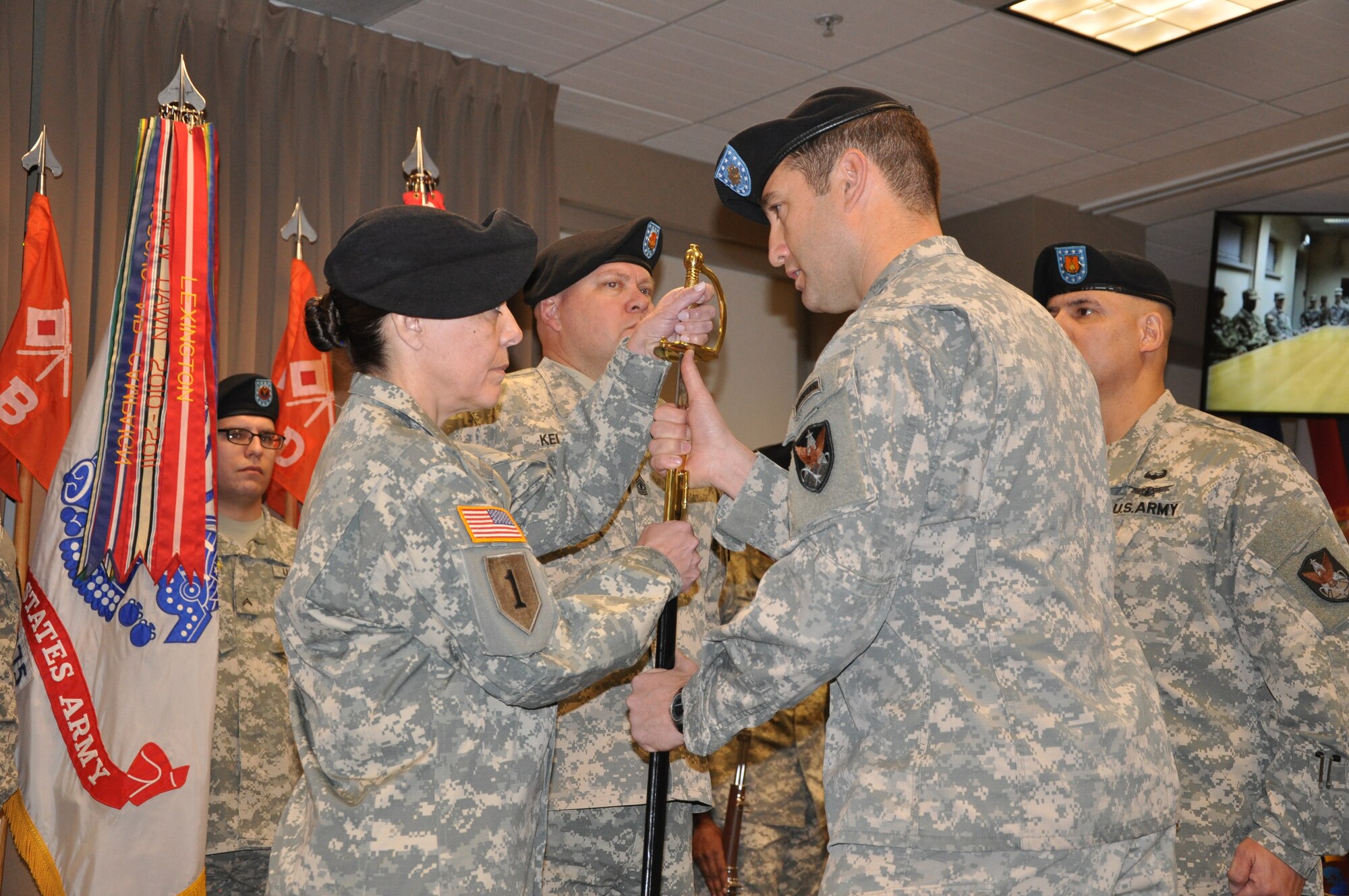 PETERSON AIR FORCE BASE, Colo. - Lt. Col. Thomas Meccia, commander, 53rd Signal Battalion, 1st Space Brigade, U.S. Army Space and Missile Defense Command/Army Forces Strategic Command, passes the U.S. Army noncommissioned officer sword to Command Sgt. Maj. Mary Carr signifying her new responsibilities as the incoming command sergeant major for the battalion. The Change of Responsibility from outgoing Command Sgt. Maj. Russell De Leon to Carr took place Dec. 21, 2015 at the command's Peterson Air Force Base, Colorado, headquarters.