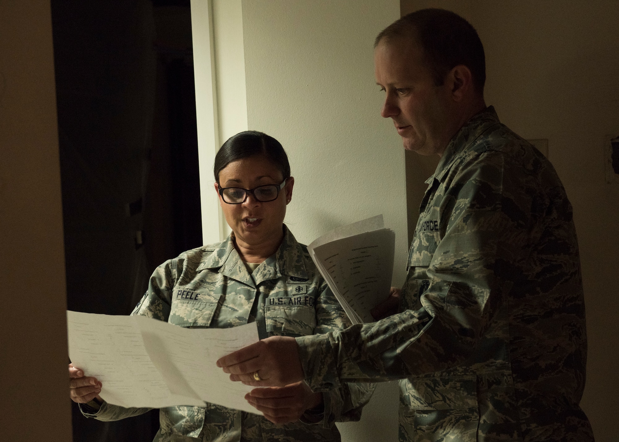 PETERSON AIR FORCE BASE, Colo. – Chief Master Sgt. Idalia Peele, 21st Space Wing command chief, and Col. Doug Schiess, 21st SW commander, deliberate and score each submission Dec. 16, 2015 for the Peterson Chapel’s annual Gingerbread House Building Competition.  Schiess and Peele were part of the judging team. (U.S. Air Force photo by Senior Airman Rose Gudex)