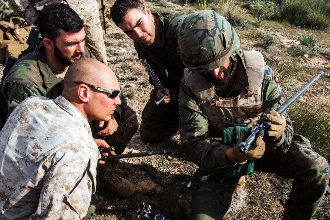 A Spanish soldier shows parts of a machine gun to U.S. Marines during a bilateral exercise between U.S. Marines and Spanish Legionnaires in Almeria, Spain, Dec. 17, 2015. The combined urban and mountain warfare training strengthens the U.S. and Spanish military relationship. Marine Corps photo by Staff Sgt. Vitaliy Rusavskiy