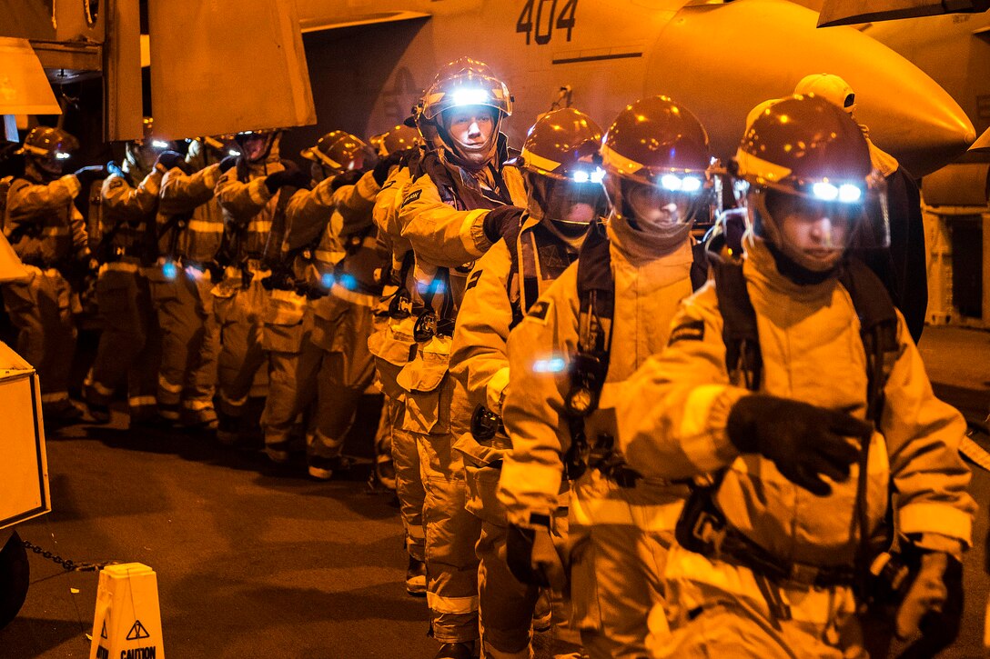 U.S. sailors move toward a simulated fire during a general quarters drill in the hangar bay of the aircraft carrier USS Harry S. Truman in the Arabian Gulf, Jan. 2, 2016. U.S. Navy photo by Petty Officer 3rd Class B. Siens