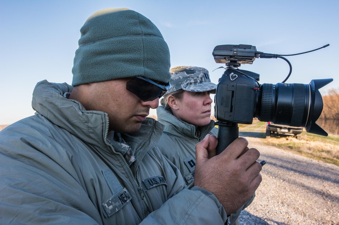Army Pvt. John Nead, assigned to the 70th Mobile Public Affairs Detachment, and Air Force Capt. Rhonda Brown assigned to the 139th Airlift Wing, Missouri National Guard conduct an interview on a levee near East Prairie, Mo., Jan. 2, 2016. Missouri Air National Guard photo by Senior Airman Patrick P. Evenson