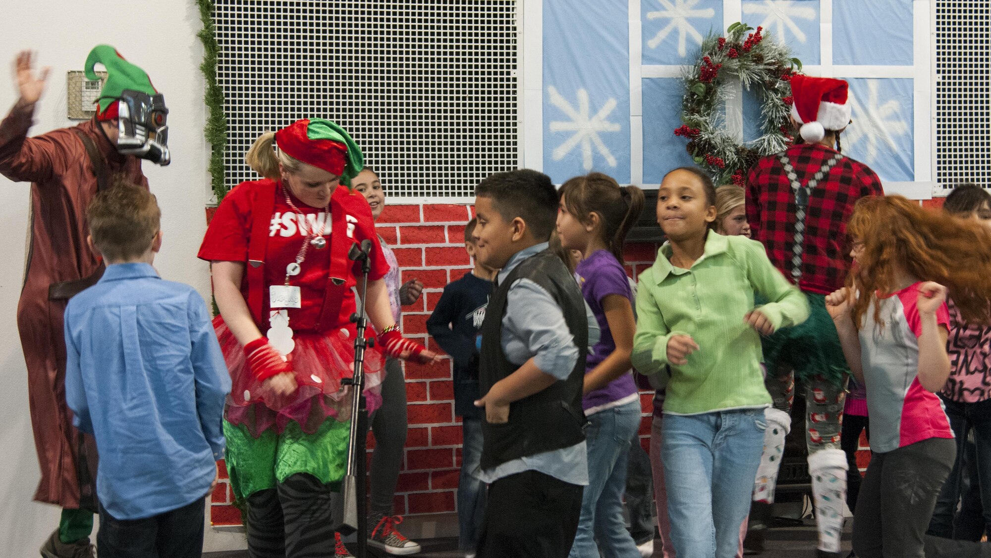 Children dance with Santa Claus' elves during the 2015 Operation Provide Joy event Dec. 12 in the Fall Hall Community Center on F.E. Warren Air Force Base, Wyo. The base and community come together each year to put on the event to bring holiday cheer to local children. (U.S. Air Force photo by Senior Airman Jason Wiese)