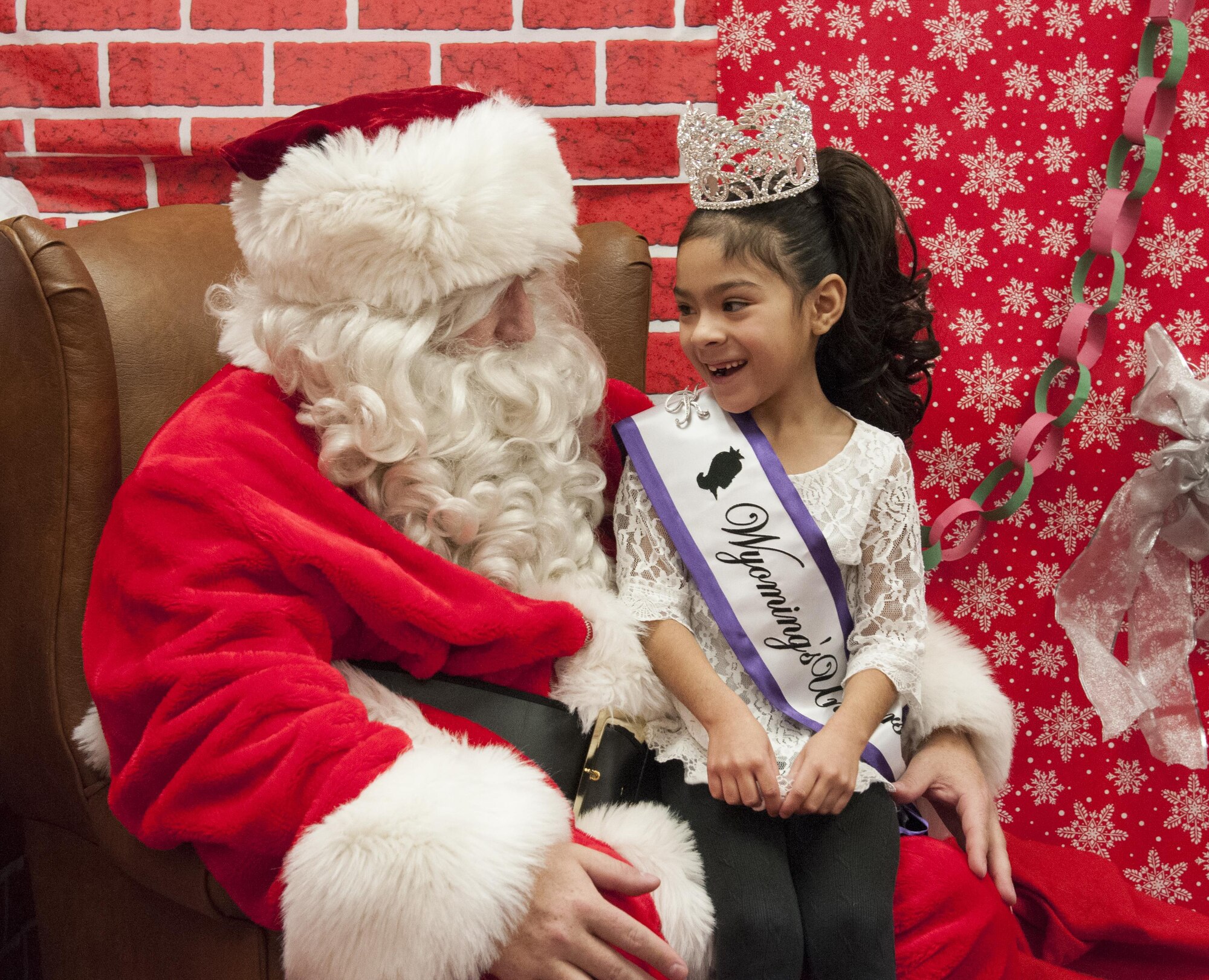 Santa Claus talks with Kasey Valerio, 6, daughter of Staff Sgt. Mario Valerio, 153rd Command and Control Squadron, during the 2015 Operation Provide Joy event  Dec. 12 in the Fall Hall Community Center on F.E. Warren Air Force Base, Wyo. Santa and his elves visited to bring holiday cheer to the children visiting the base from the local community. (U.S. Air Force photo by Senior Airman Jason Wiese)