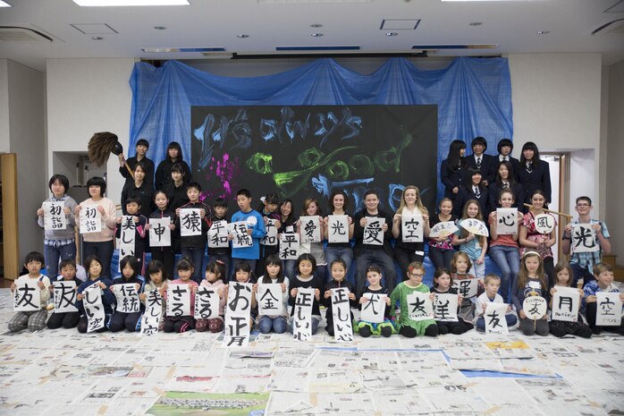 Marine Corps Air Station Iwakuni home-schoolers pose for a group picture with the Calligraphy Club from Kannon High School, Hiroshima, during a calligraphy event at the Waki General Community Center in Waki Town, Japan, Jan. 4, 2016. This event allowed the home-schoolers to learn about the culture that they are now a part of. Community relations events like these help bolster the relationship between the station and the local Japanese community.