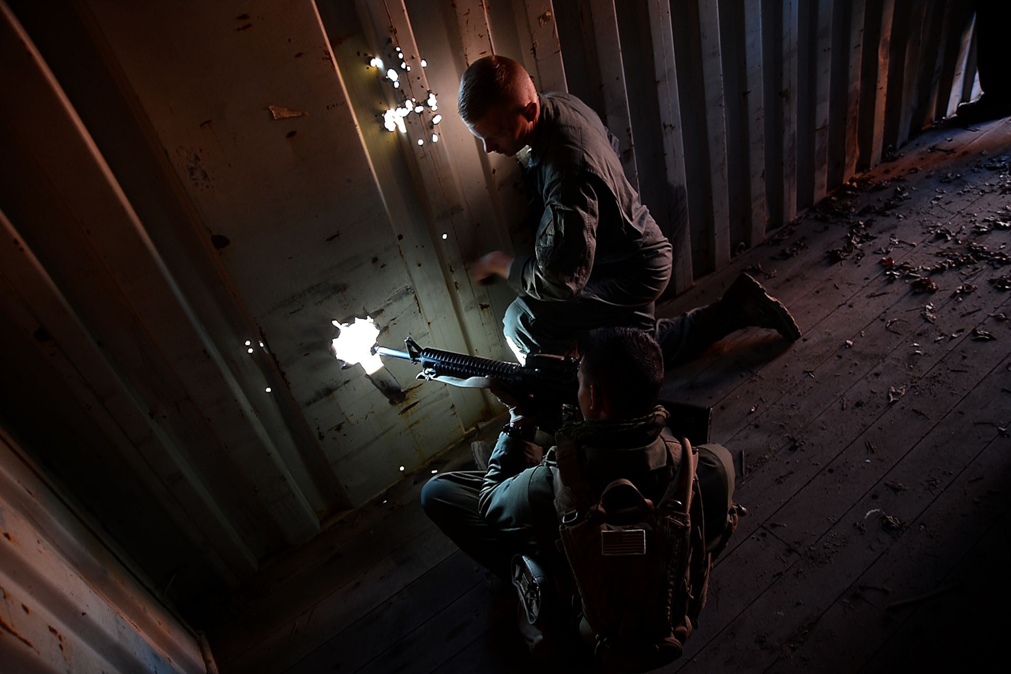 U.S. Marines assigned to Marine Aviation Logistics Squadron 31 stationed at Marine Corps Air Station Beaufort, S.C., look out the holes of a shipping container while waiting for a convoy to arrive at Poinsett Electronic Combat Range, Wedgefield, S.C., Dec. 10, 2015. The Marines were waiting for the convoy so they could ambush them, testing their reaction. (U.S. Air Force photo by Senior Airman Michael Cossaboom)