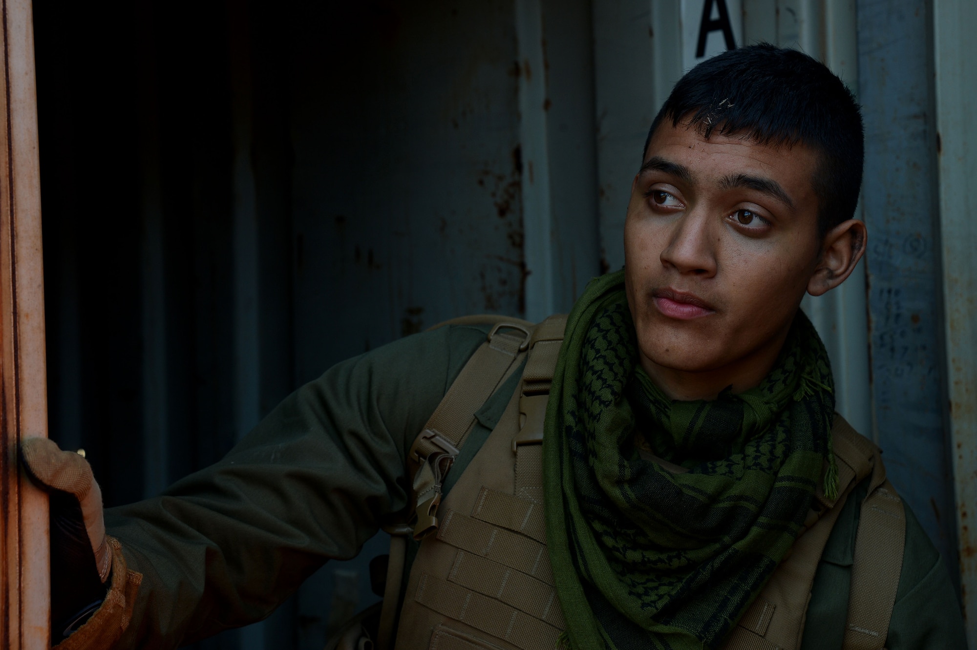 A U.S. Marine assigned to Marine Aviation Logistics Squadron 31 stationed at Marine Corps Air Station Beaufort, S.C., looks out the side of a shipping container at Poinsett Electronic Combat Range, Wedgefield, S.C., Dec. 10, 2015. The Marine was a part of the enemy Red Cell team which was tasked to engage Marine Wing Support Squadrons 273’s air base defense unit at various times throughout the week. (U.S. Air Force photo by Senior Airman Michael Cossaboom)