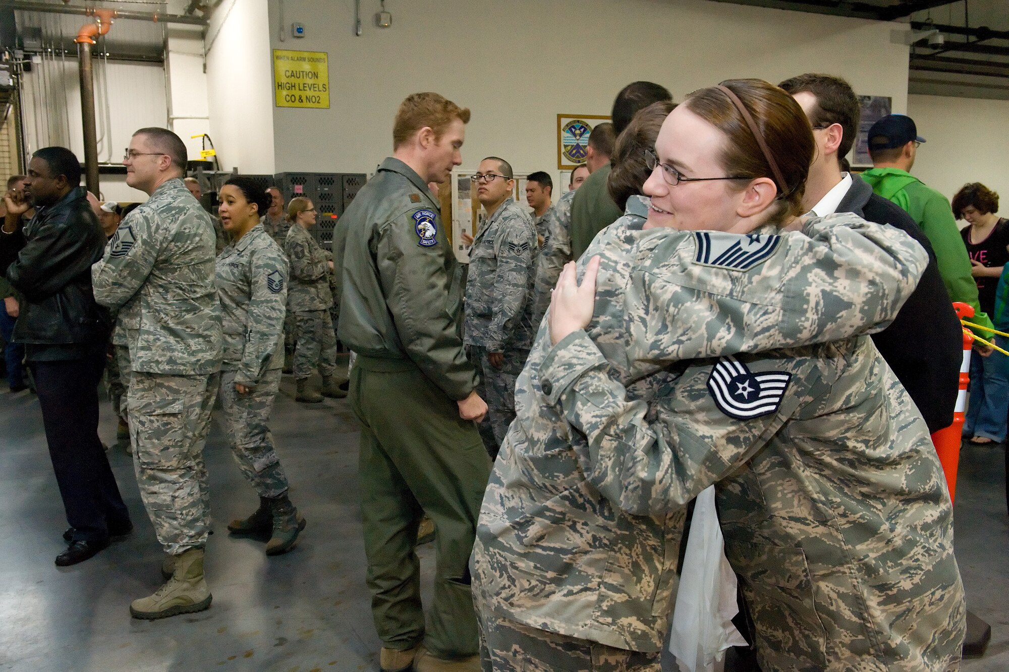 Tech. Sgt. Helena Cox, 436th Aerial Port Squadron Port Dawg upgrade training facilitator, right, receives a congratulatory hug from Senior Master Sgt. Jennifer Nesbitt, 436th APS air terminal manager, after being promoted under the Stripes for Exceptional Performers program Dec. 22, 2015, on Dover Air Force Base, Del. Cox was promoted to technical sergeant on the spot by Col. Michael Grismer, 436th Airlift Wing commander, prior to the 11th Annual Feed the Troops event that was held in building 550. (U.S. Air Force photo/Roland Balik)