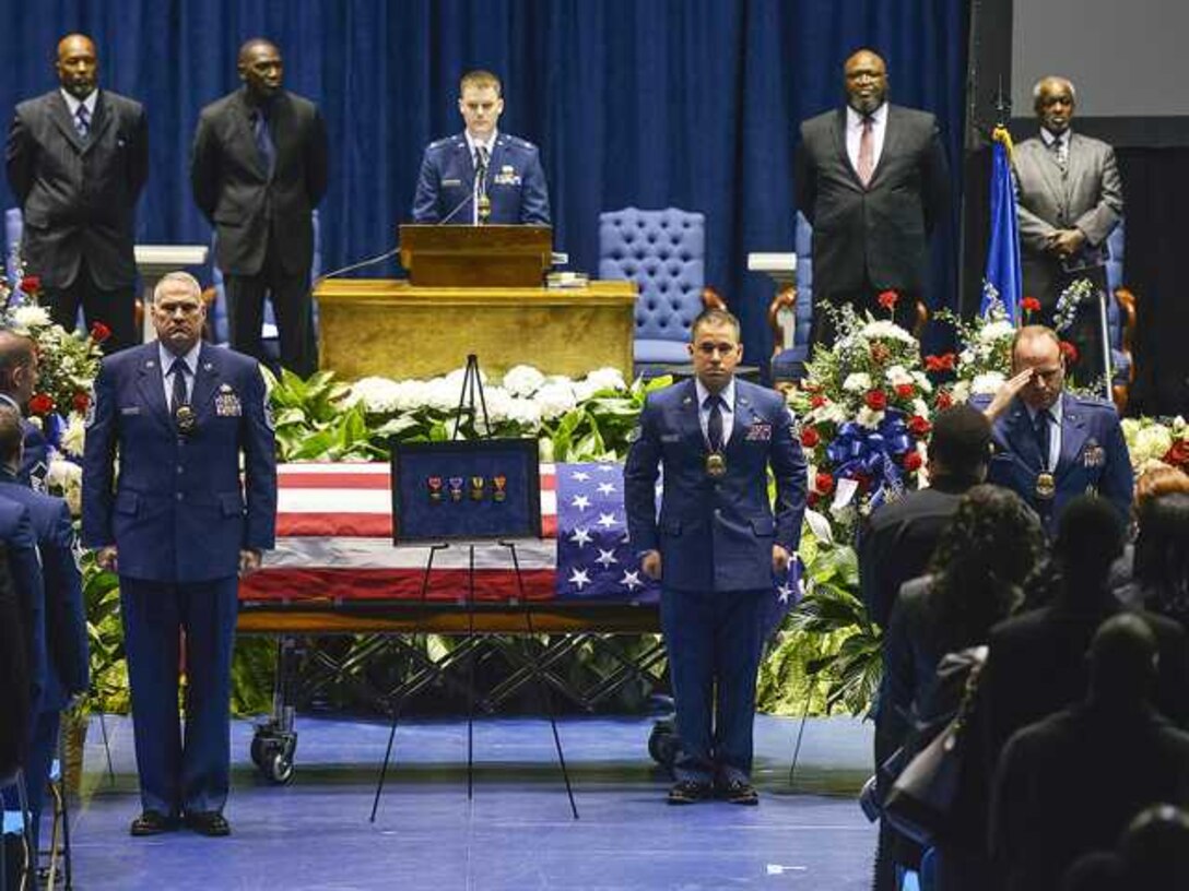 Annie McBride is saluted after her son, Air Force Staff Sgt. and Special Agent Chester McBride, is posthumously awarded four medals for his actions and service by Air Force Office of Special Investigations officials during McBride's funeral at Georgia Southern University's Hanner Fieldhouse Jan. 2. (Photo courtesy Statesboro Herald.com)