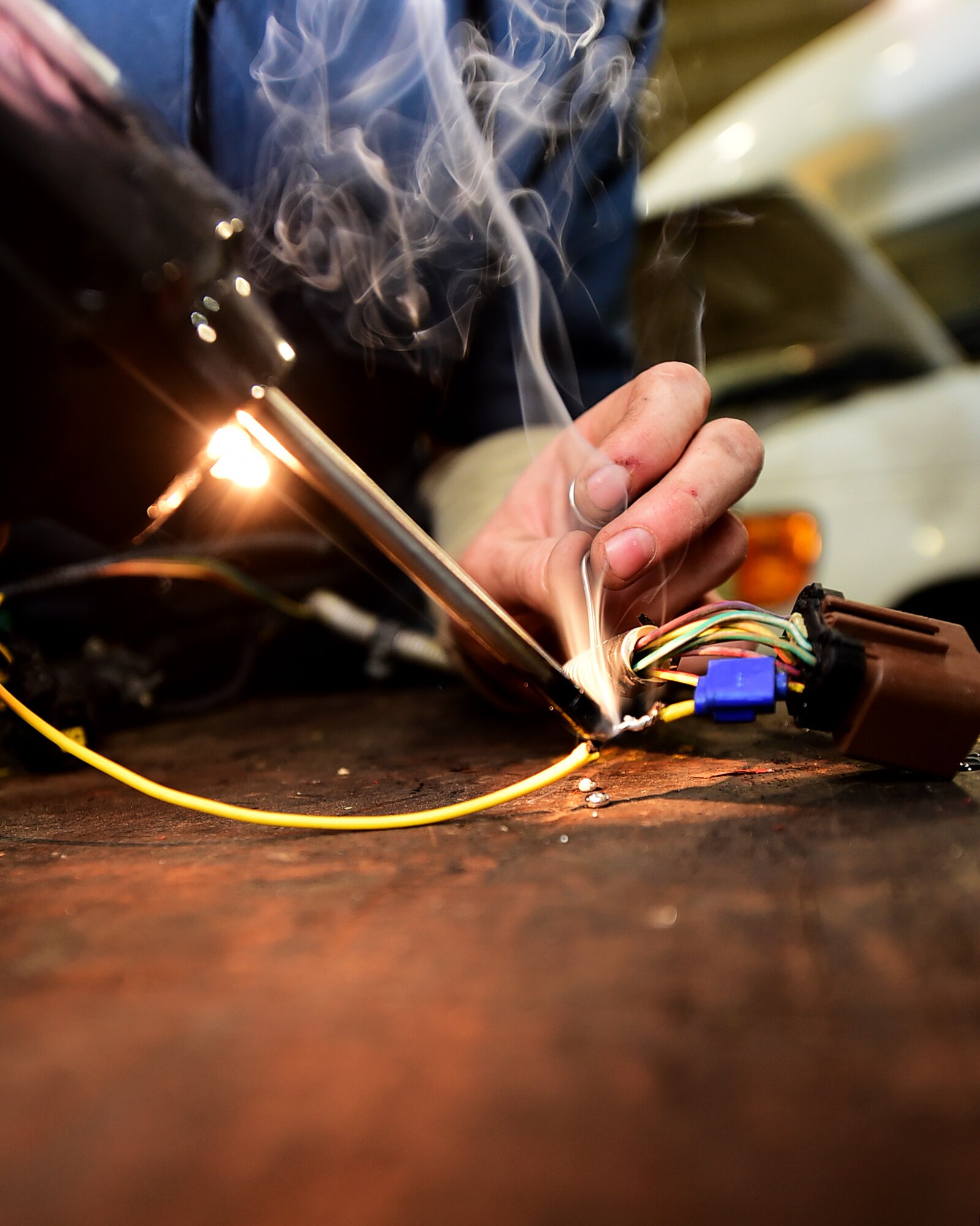 Senior Airman Troy Noel, 386th Vehicle Management Flight, mission generation vehicular equipment maintenance journeyman , solders a transmission harness at an undisclosed location in Southwest Asia, Jan. 4, 2016. The vehicle management flight completes approximately 500 work orders a month servicing various types of vehicles such as fire trucks, cargo loaders, and aircraft refueling trucks supporting Operation INHERENT RESOLVE. (U.S. Air Force photo by Staff Sgt. Jerilyn Quintanilla)