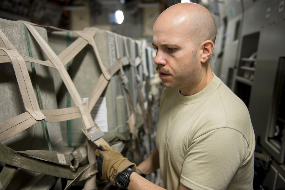U.S. Air Force Tech. Sgt. Paul Mooney prepares cargo for travel at Al Udeid Air Base, Qatar, in support of Operation Inherent Resolve, Dec. 22, 2015. Mooney is a loadmaster assigned to the 816th Expeditionary Airlift Squadron loadmaster. U.S. Air Force photo by Tech. Sgt. Nathan Lipscomb    