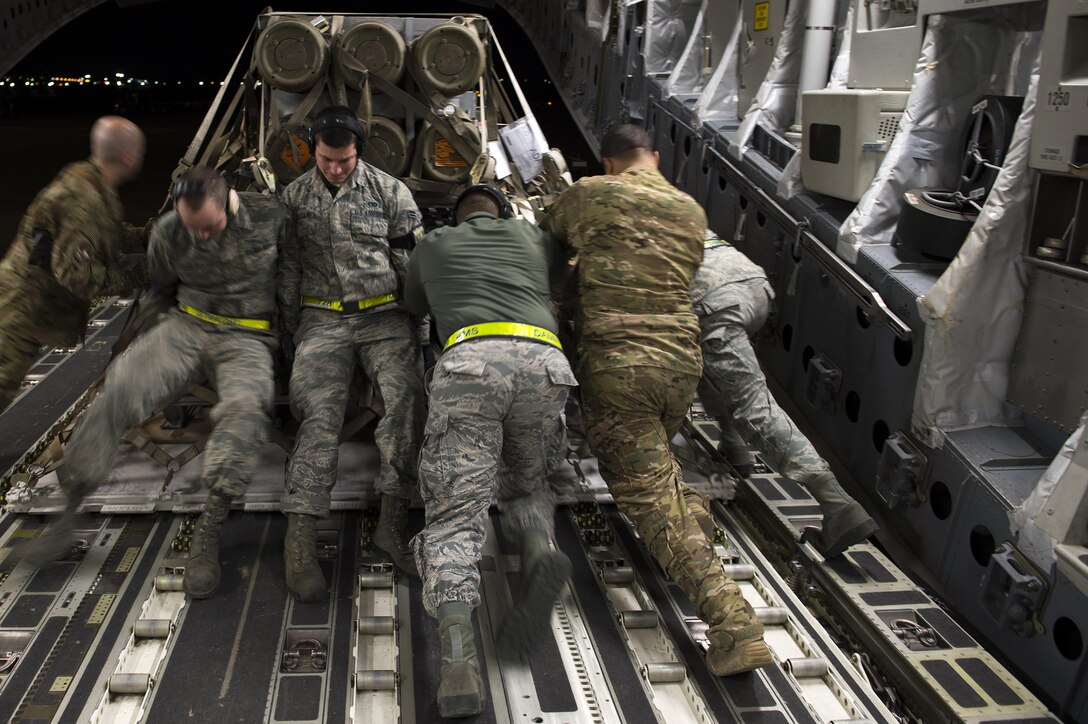 U.S. airmen push a heavy bundle of cargo off a C-17 Globemaster III as they deliver it to Incirlik Air Base, Turkey, in support of Operation Inherent Resolve, Dec. 22, 2015. Inherent Resolve is the coalition intervention against the Islamic State of Iraq and the Levant. U.S. Air Force photo by Tech. Sgt. Nathan Lipscomb