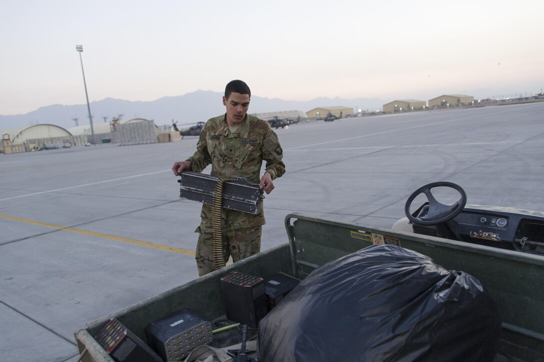 U.S. Army Spc. Perez off loads an ammo canister from a CH-47 Chinook helicopter before a wash down and inspection at Bagram Airfield, Afghanistan, Dec. 29, 2015. U.S. Army photo by Sgt. 1st Class Nathan Hutchison    