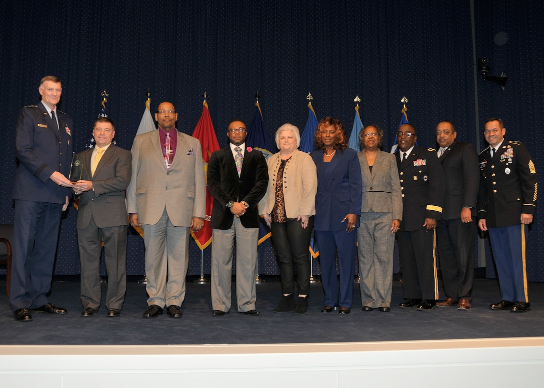 DLA director Air Force Lt. Gen. Andy Busch, left, presents the DLA Distribution Red River, Texas, Equal Employment Office team (left to right: Kirby Olson, Willie Houff, Kacy Harvey, Gina Edwards, Melba Golston and Jo Linda Warren) the Outstanding Achievement in EEO award at the 48th annual employee recognition ceremony Dec. 10.  Distribution’s commander Army Brig. Gen. Richard Dix, third from right, DLA’s equal employment opportunity director Ferdinand LeCompte, second from right, and DLA’s Senior Enlisted Leader Army Command Sgt. Maj. Charles Tobin, right, were also on-hand to present the award.  (Photo by Teadora Mocanu)