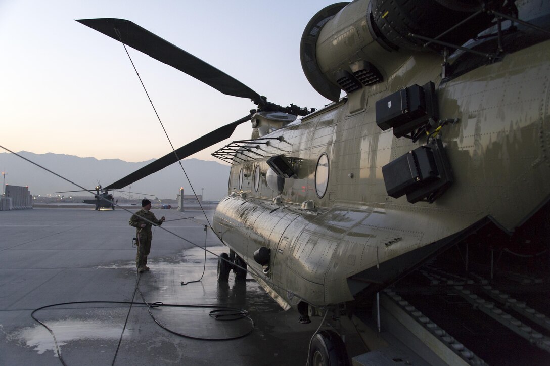 A U.S. soldier rinses off a CH-47 Chinook helicopter at Bagram Airfield, Afghanistan, Dec. 29, 2015. U.S. Army photo by Sgt. 1st Class Nathan Hutchison